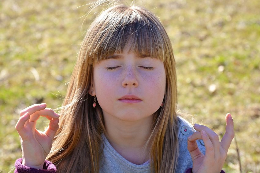 Kind meditiert in der Natur